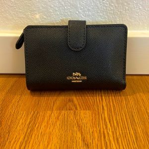 Small black leather COACH wallet with gold zipper and logo